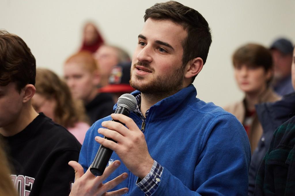 A student asks a question from the crowd of a President's Forum
